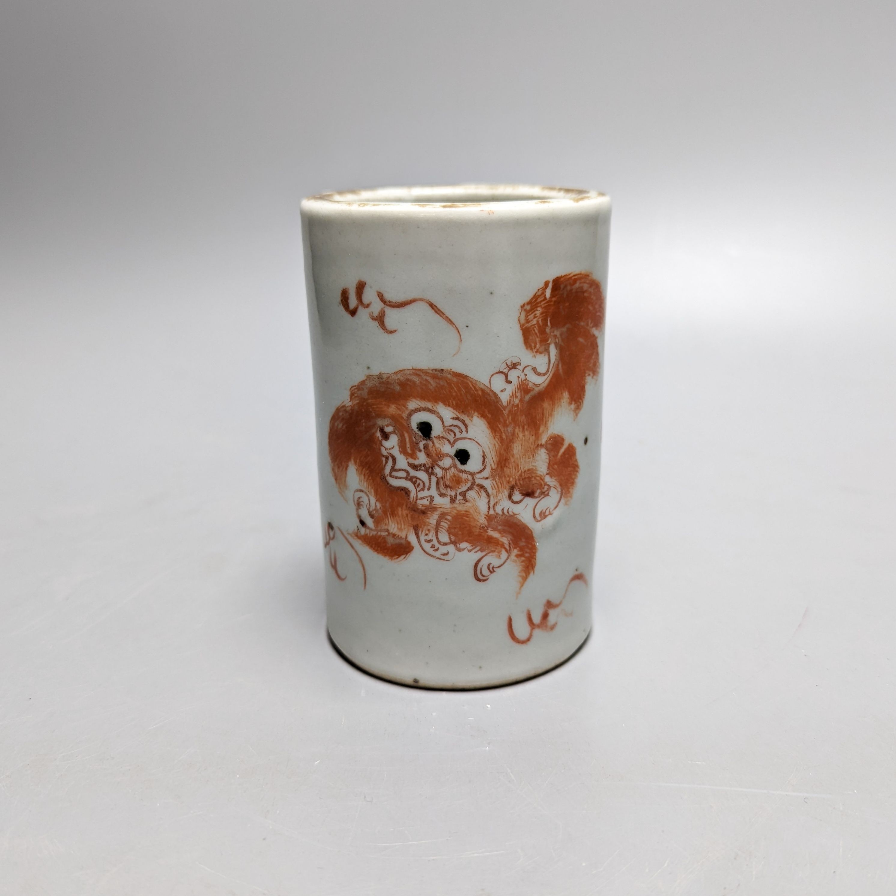 An early 20th century iron red enamelled 'lion' brush pot 12cm
